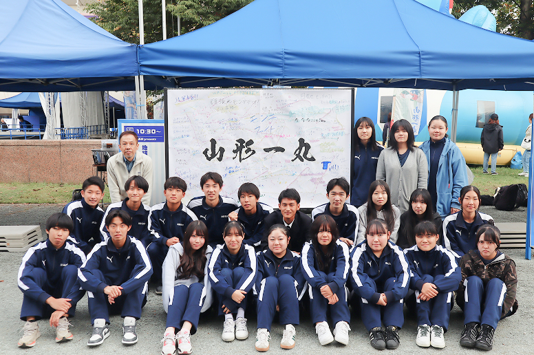 イベントに参加した惺山高等学校の生徒と寄せ書きボード